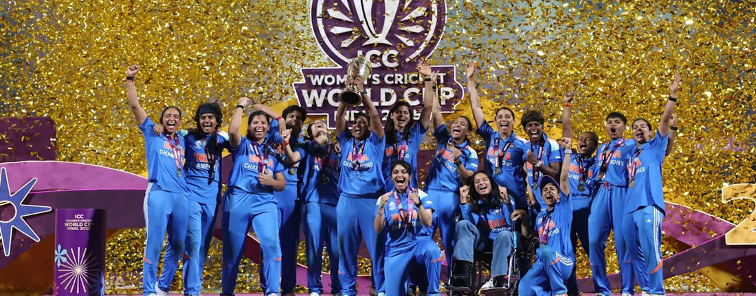 India Women’s Cricket Team celebrates winning the ICC World Cup 2025 — players in blue jerseys holding the trophy with golden confetti in the background, symbolizing victory and pride — ZHome jewellery brand celebrating women’s strength and success.