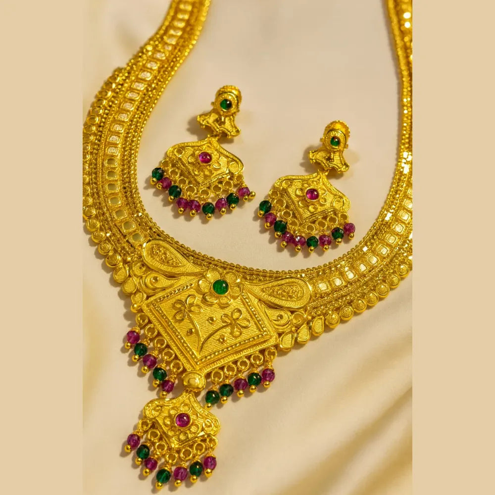 Model wearing OneGram gold temple long necklace and earrings, featuring dual square pendants with red and green stone detailing.